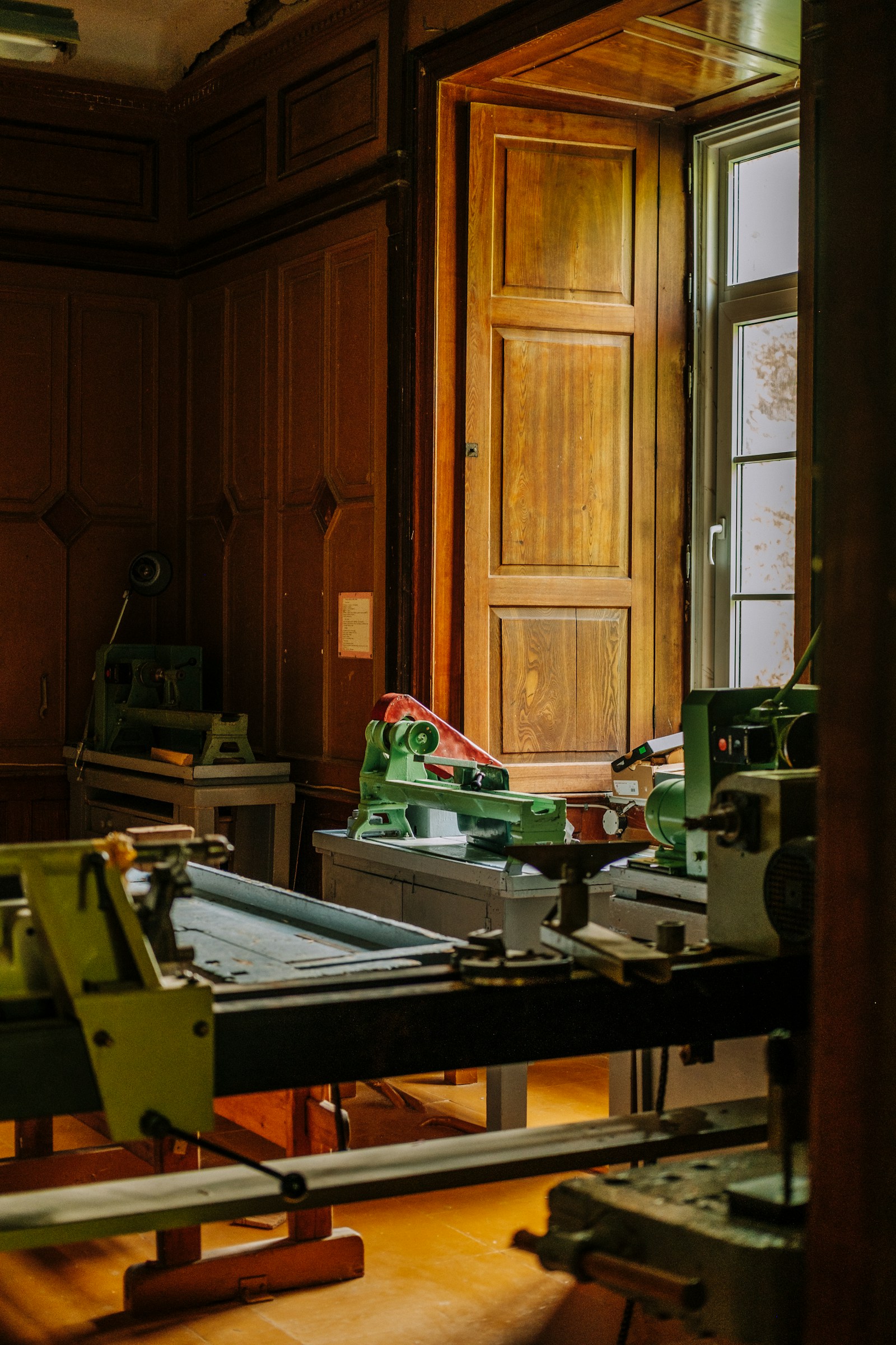 Machines dans un atelier éclairé par une grande fenêtre.
